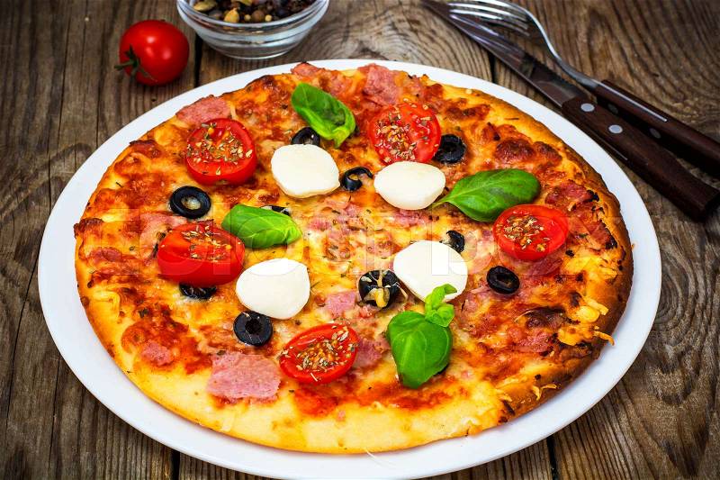Italian pizza with ham, cheese, mushrooms, tomatoes and mozzarella. Studio Photo, stock photo
