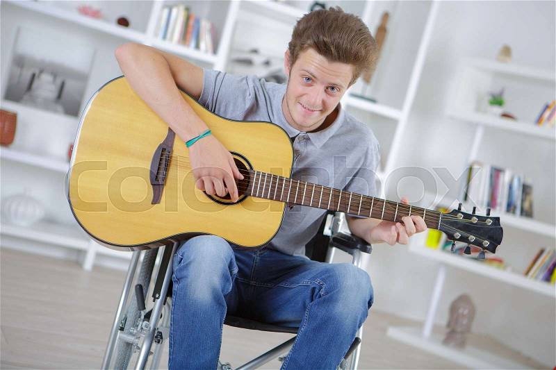 Portrait of cheerful handicapped man with guitar, stock photo