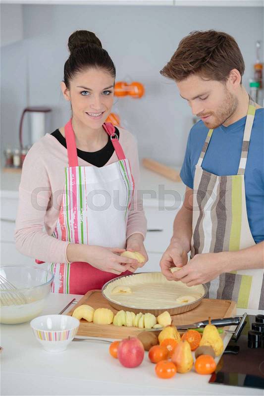 Young woman and man baking a cake, stock photo