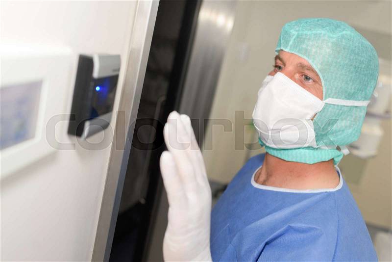 Surgeon in mask ready to enter operating room at hospital, stock photo