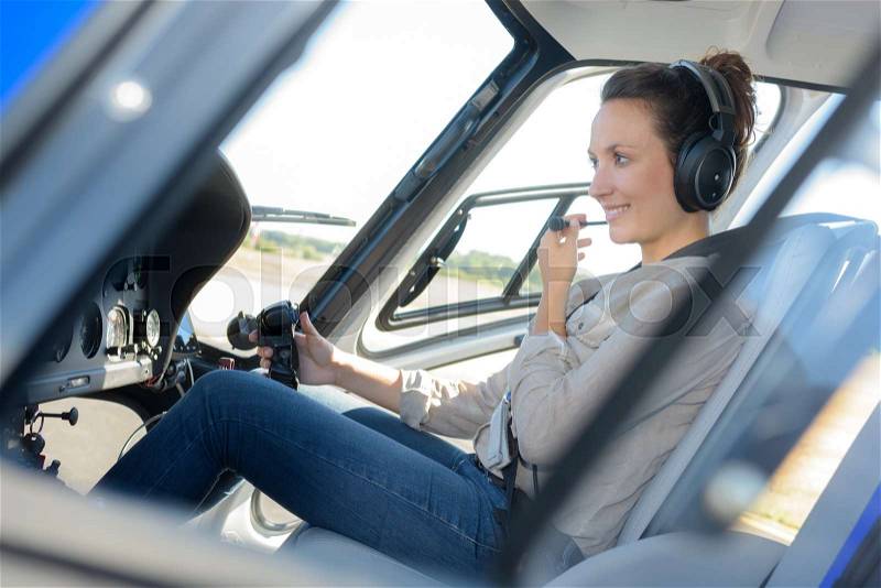 Portrait of young beautiful woman pilot in a airplane, stock photo