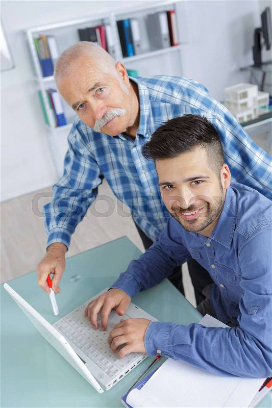 Happy business partners or co-worker behind a desktop computer, stock photo