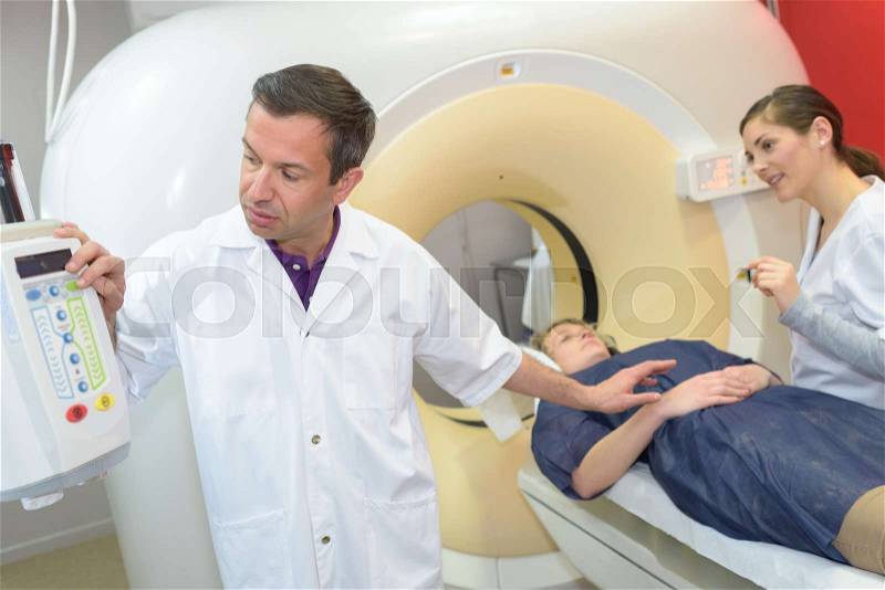 Professional with patient and doctor using cat scan, stock photo