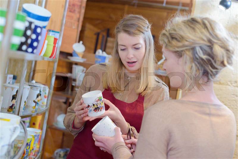 Shop assistant of a tea-shop helping customer to choose, stock photo