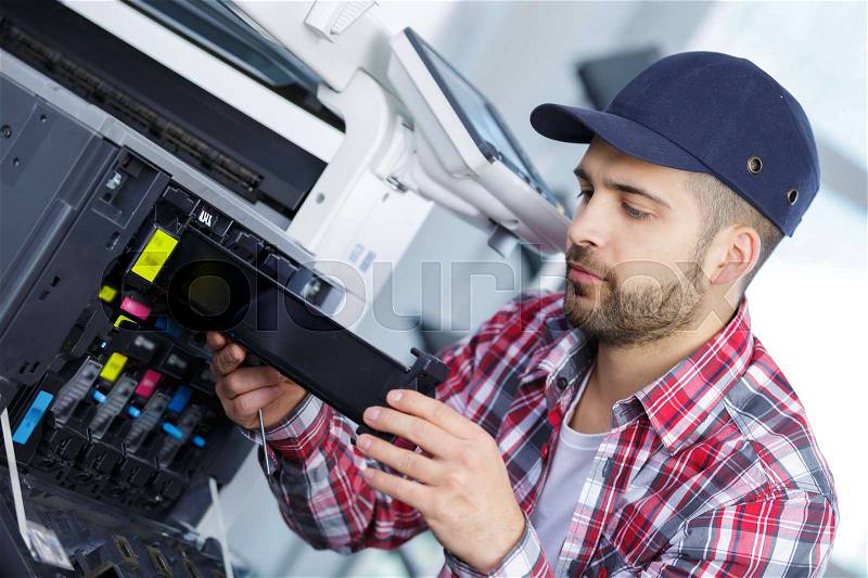 Man repairing a printer at work, stock photo