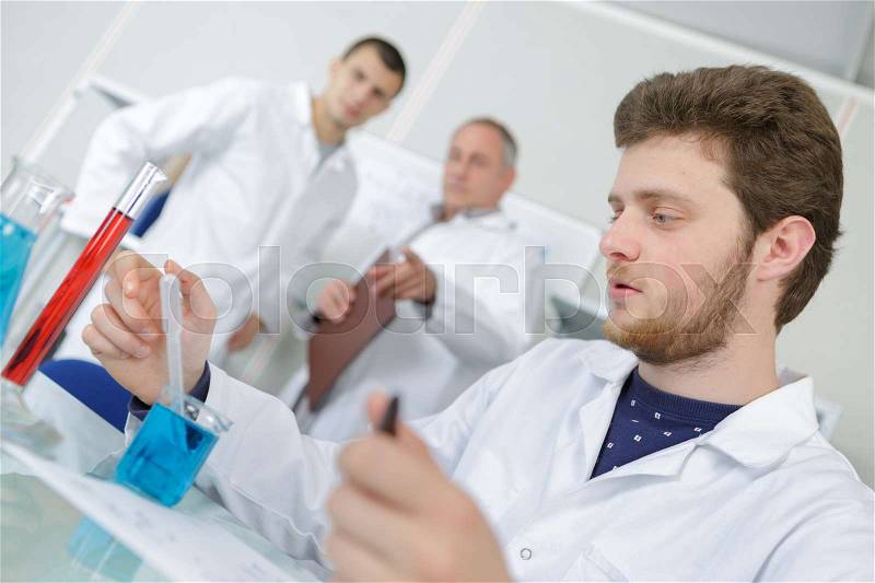 Young chemist working with tubes in laboratory, stock photo