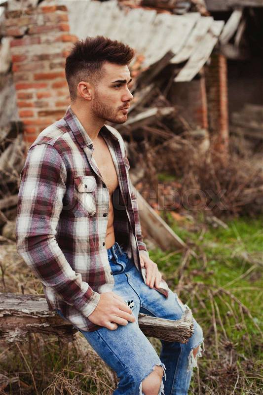Attractive guy showing his strong chest and abs with the plaid shirt open, stock photo
