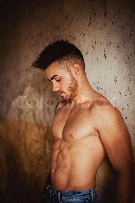 Attractive guy with the torso discovered showing his muscles, stock photo