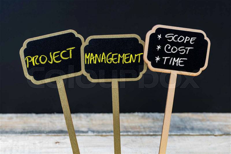 Concept message PROJECT MANAGEMENT - SCOPE, COST, TIME written with chalk on wooden mini blackboard labels, defocused chalkboard and wood table in background, stock photo