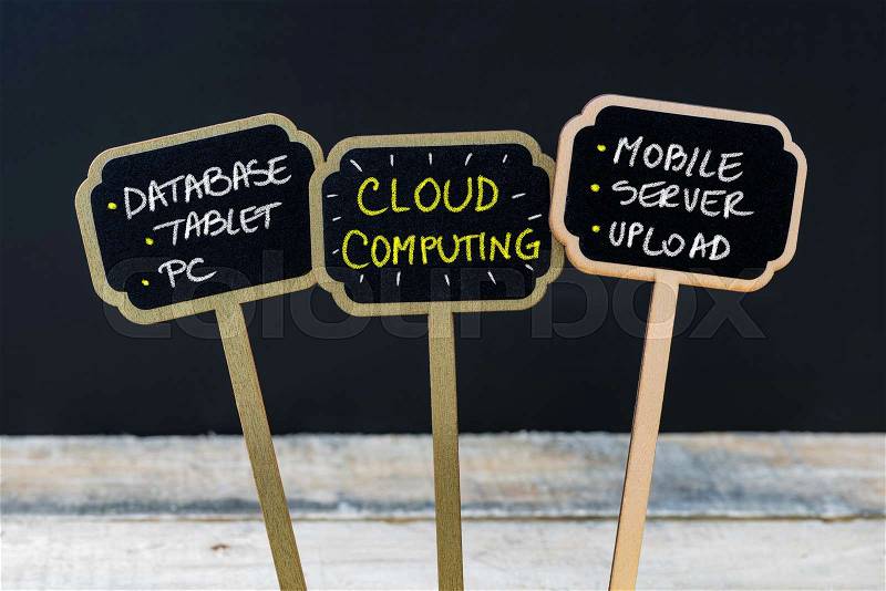 Concept message CLOUD COMPUTING written with chalk on wooden mini blackboard labels, defocused chalkboard and wood table in background, stock photo