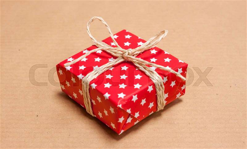 Red christmas present on craft paper background, stock photo