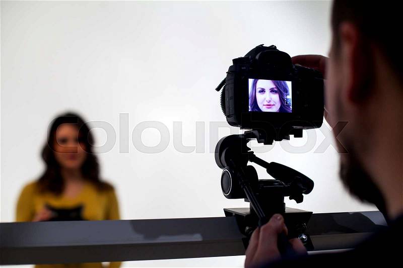 Backstage from video studio with woman going to wear virtual reality headset on white background, stock photo