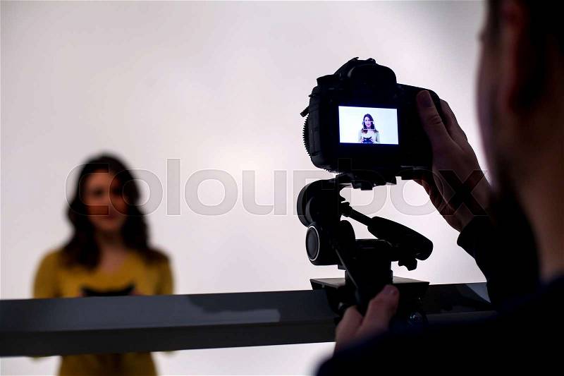 Backstage from video studio with woman going to wear virtual reality headset on white background, stock photo