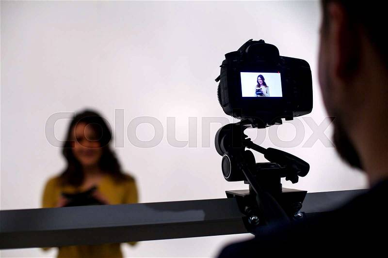 Backstage from video studio with woman going to wear virtual reality headset, stock photo