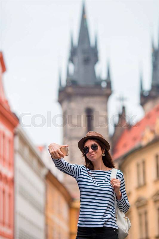 Happy young woman taking selfie background famous castle in european city. Caucasian tourist walking along the deserted streets of Europe. Warm summer early morning in Prague, Czech Republic, stock photo