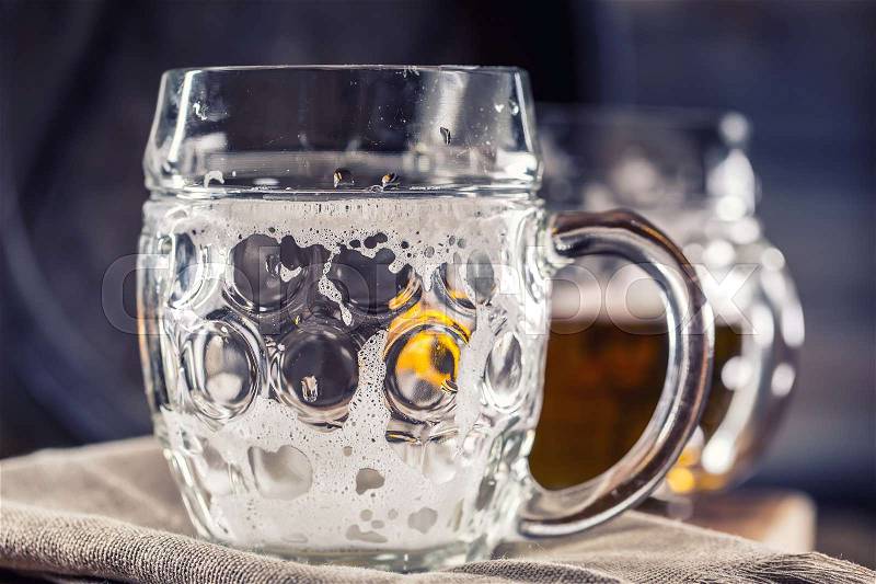 Beer. Two cold beers. Draft beer. Draft ale. Golden beer. Golden ale. Two gold beer with froth on top. Draft cold beer in glass jars in home pub hotel or restaurant. Empty beer glass. Still life, stock photo