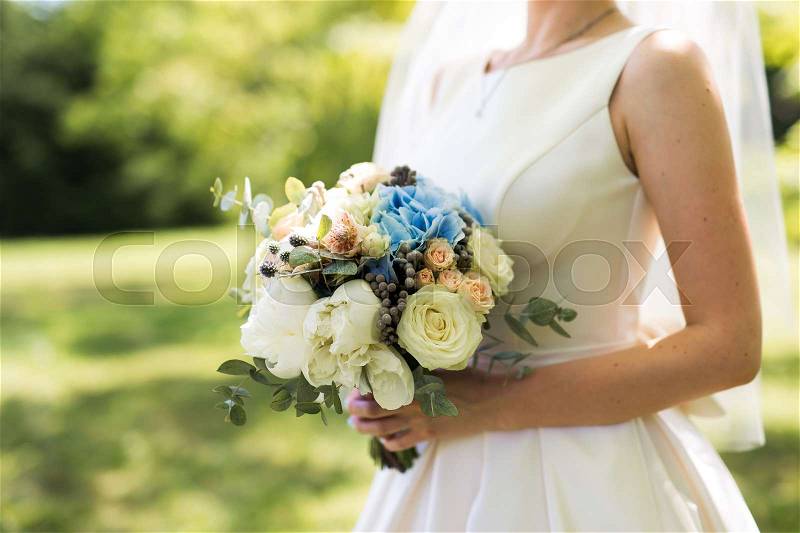 Closeup photo of bride holding a flower bouquet. wedding decoration background, stock photo