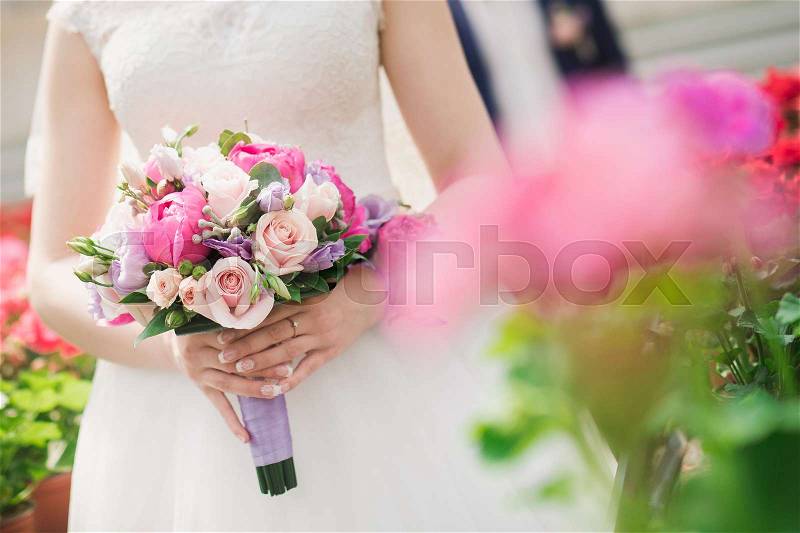 Closeup photo of bride holding a flower bouquet. wedding decoration background, stock photo