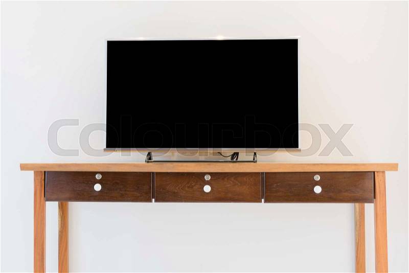 Led smart TV on wooden shelf over white wall background, stock photo