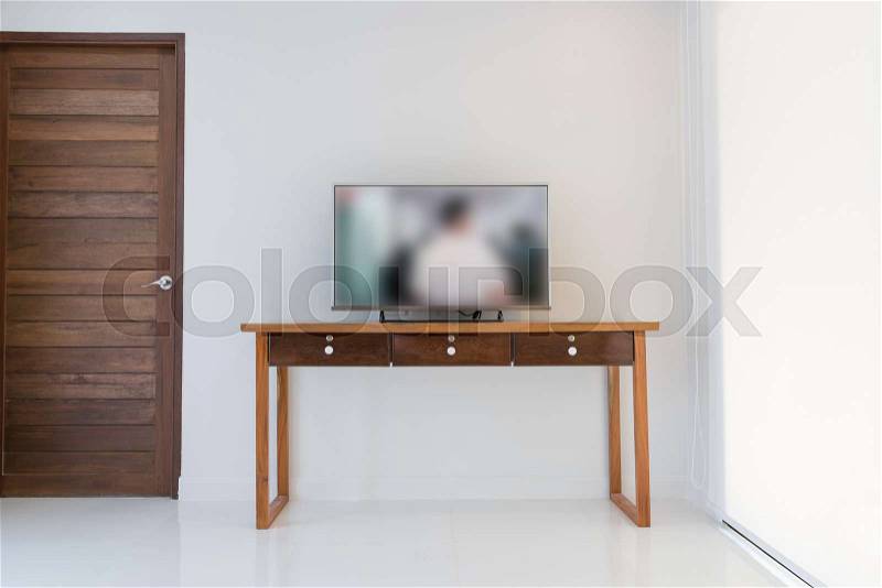 Led smart TV on wooden shelf over white wall background in modern interior white living room, stock photo