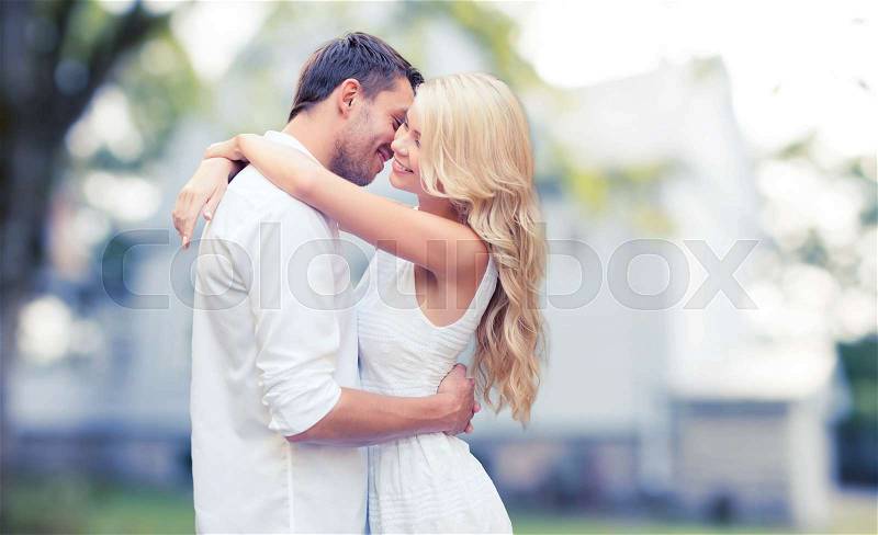 Home, real estate, people, love and dating concept - happy couple hugging over summer house background, stock photo
