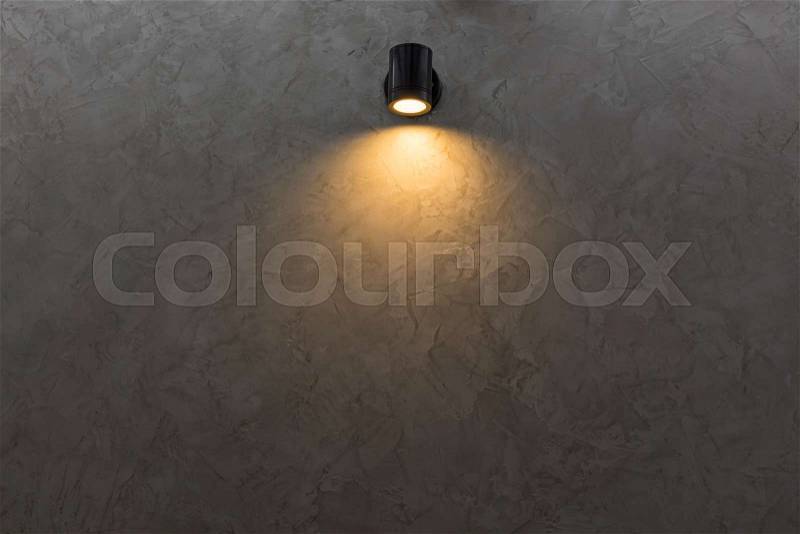 Black wall lamp on grey mortar wall background, stock photo
