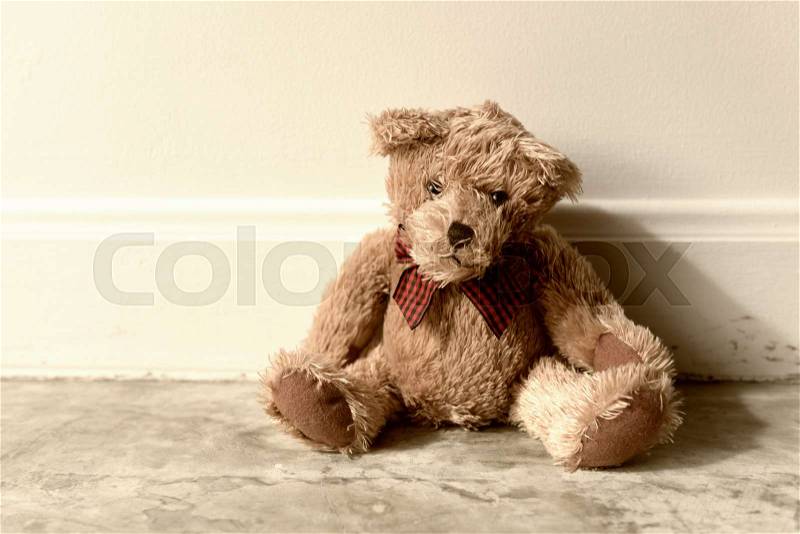 Vintage teddy bear alone in room, stock photo