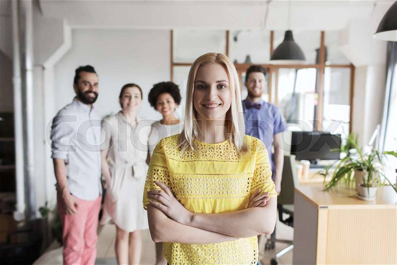 Business, startup, people and teamwork concept - happy young woman over creative team in office, stock photo