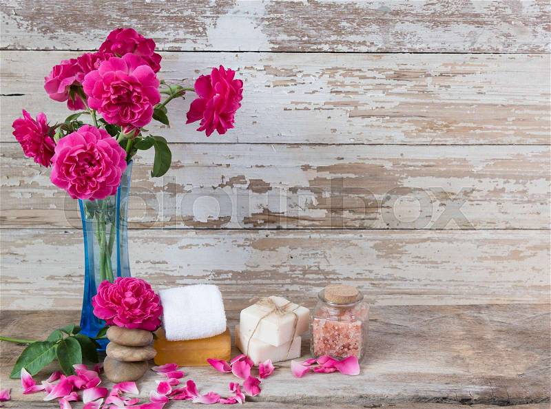 Spa concept with coconut soap,salt,zen stone and beautiful rose flowers on grunge wooden background , stock photo