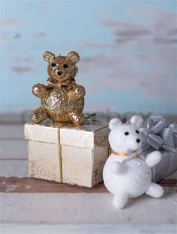 Christmas cute gold teddy bear and golden gift box on wooden background, stock photo