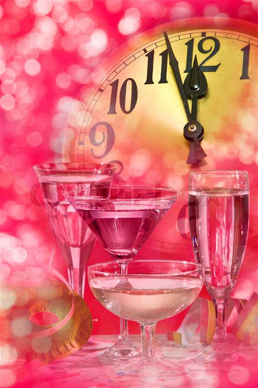 New year clock and wine glasses on the pink background, stock photo