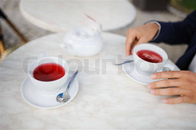 Groom and bride are drinking red tea outdoors, stock photo