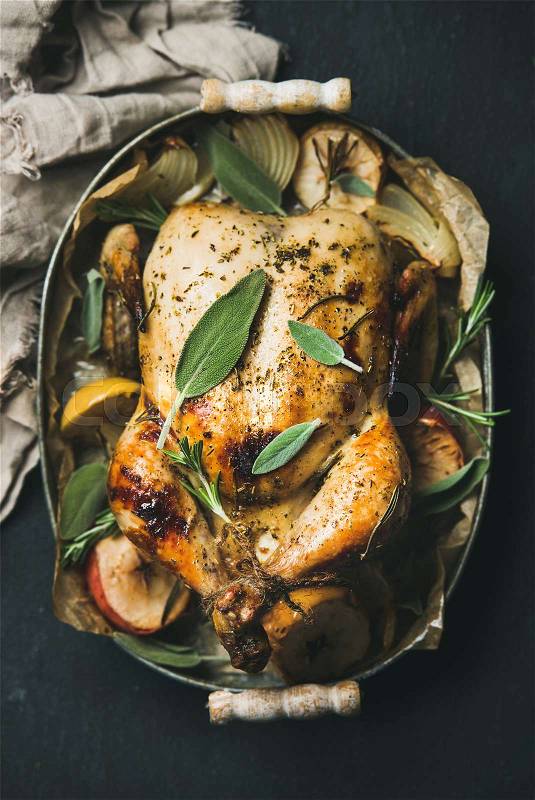 Oven roasted whole chicken with apples, onion and sage leaves, stock photo