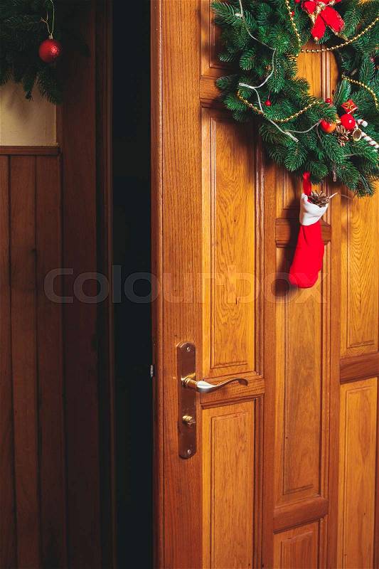 Christmas wreath with red sock and border on the door, stock photo