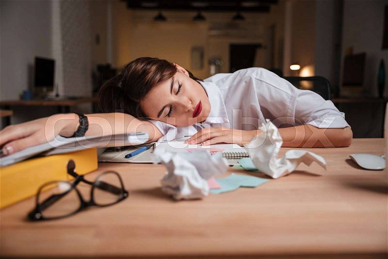 Weary business woman. sleeping on the table, stock photo