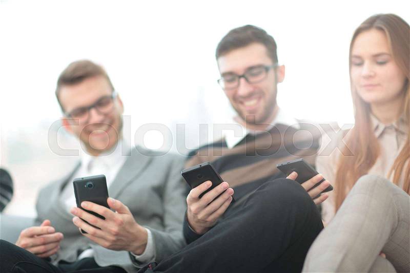A group of young and happy young people using their phones and communicate, stock photo