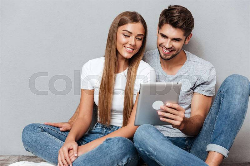 Pretty couple with the tablet. looking into tablet, stock photo