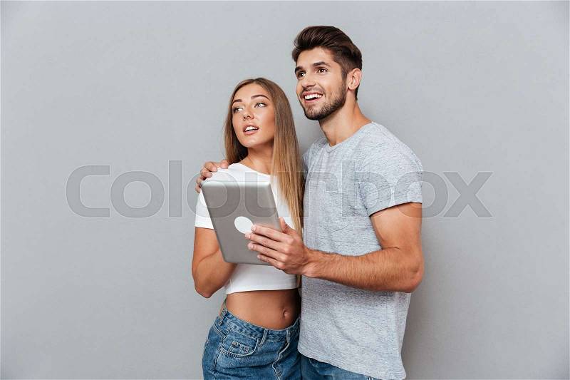 Thoughtful couple with tablet. Looking up, stock photo