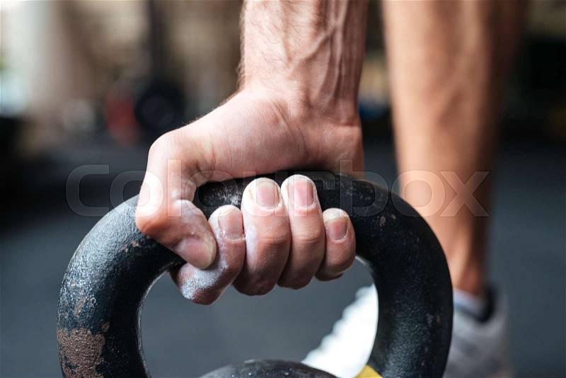 Close up image of fitness hand and kettlebell. preparing to raise, stock photo