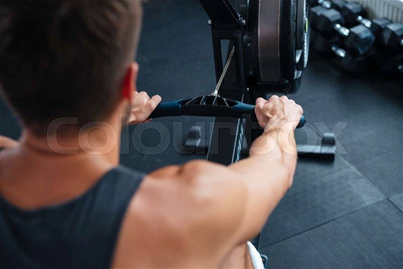 Photo from the back of fitness man. Exercise for your hands, stock photo