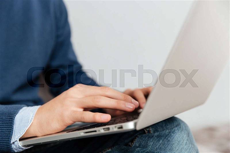 Close up image of asian man with laptop. sitting down. gray background, stock photo