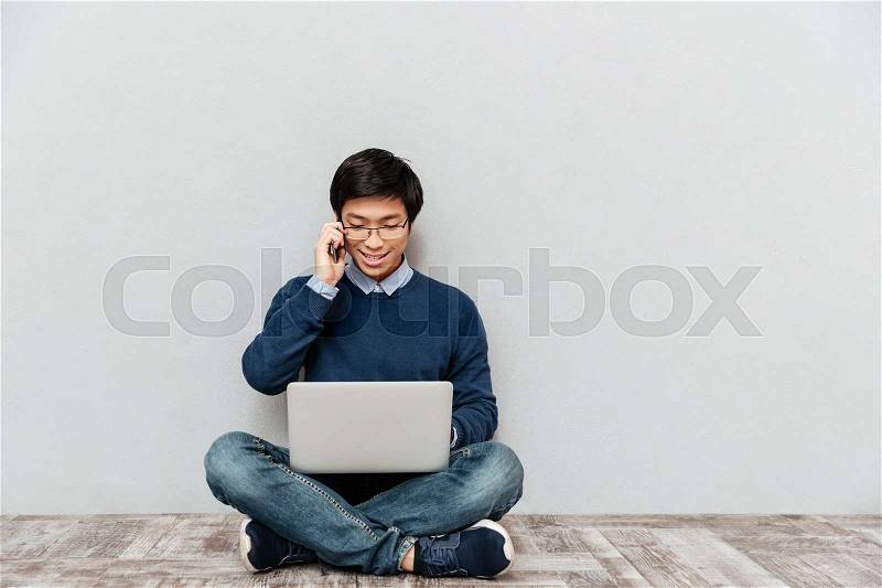 Asian man with phone and laptop. sitting down, stock photo