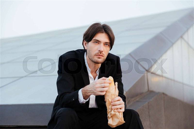 Man in suit with baguette. near the glass, stock photo