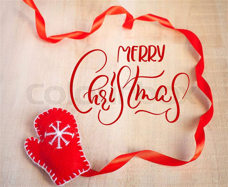 Christmas Background with Santa Claus red mitten and text Merry Christmas. Calligraphy lettering, stock photo