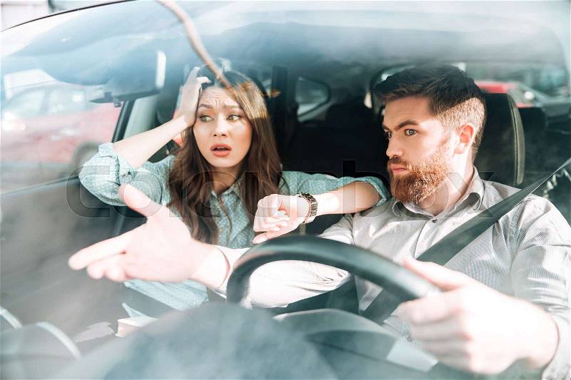 Couple have a dispute in car. woman holding her head, stock photo