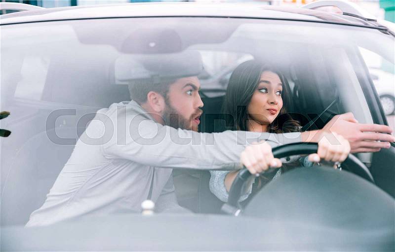 Fashion woman and man in car. man shows away. woman at the wheel, stock photo