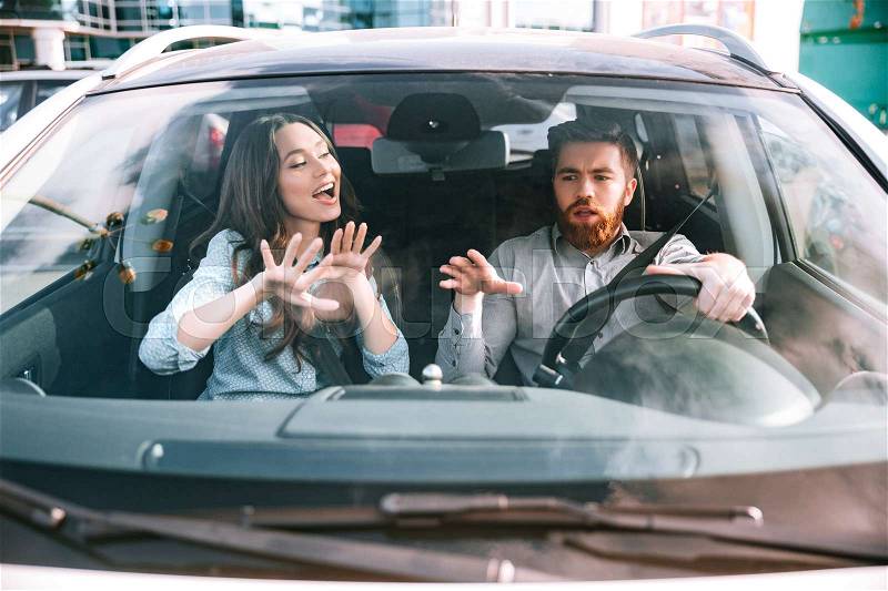 Funny couple in car. man at the wheel. front image, stock photo