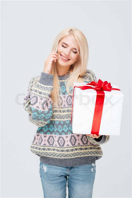 Pretty model in sweater with gift. eyes closed, stock photo