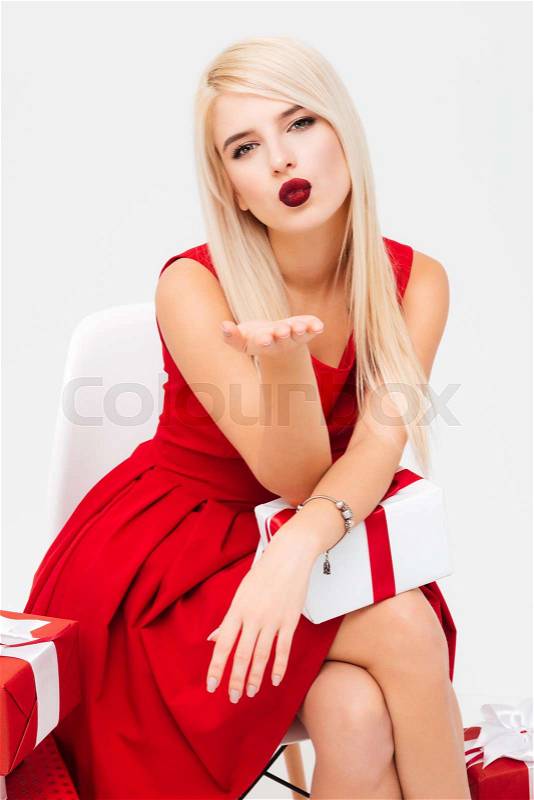 Christmas woman sends an air kiss. near gifts, stock photo