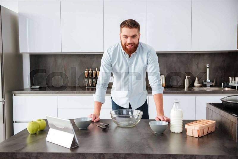 Man in kitchen. looking at camera, stock photo